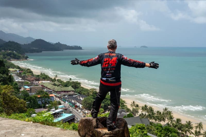 Motorcycle rider overlooking dramatic cliff scenery in Thailand