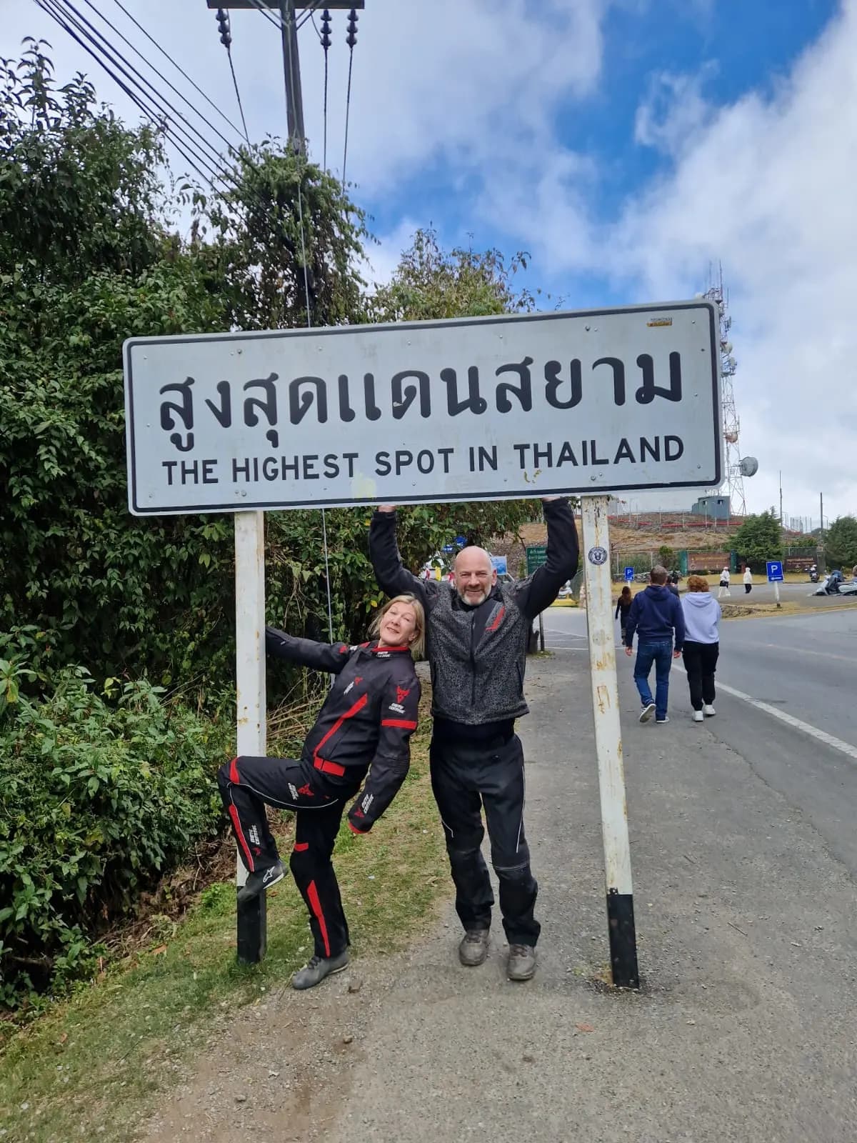 Riders posing infront of a sign