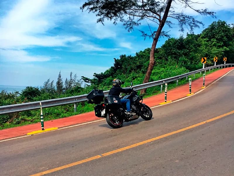 Rider cruising along a scenic coastal road with ocean views
