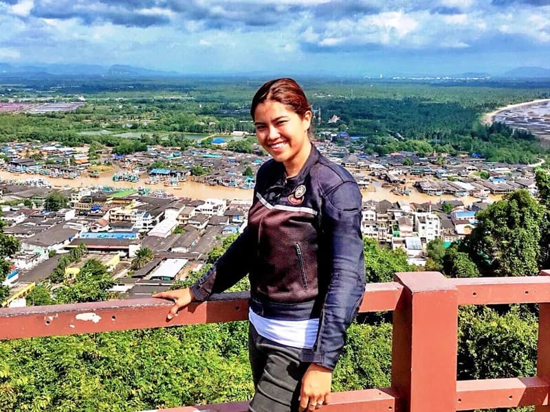 Rider at elevated viewpoint overlooking coastal town and mountains
